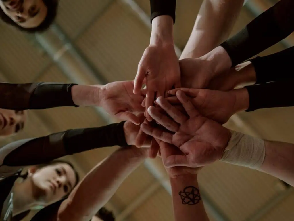 Team joins hands in a circle